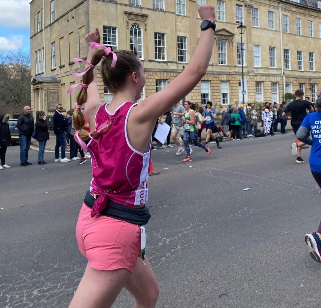 Marathon runner celebrating with her hands in the air
