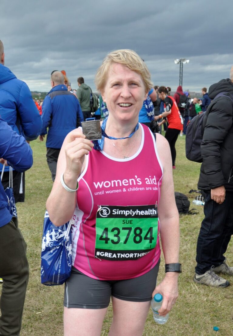 Women's Aid runner holding medal