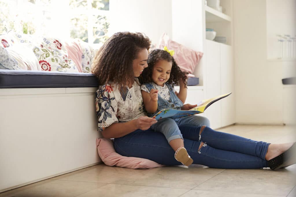 Woman and child reading a book and smiling
