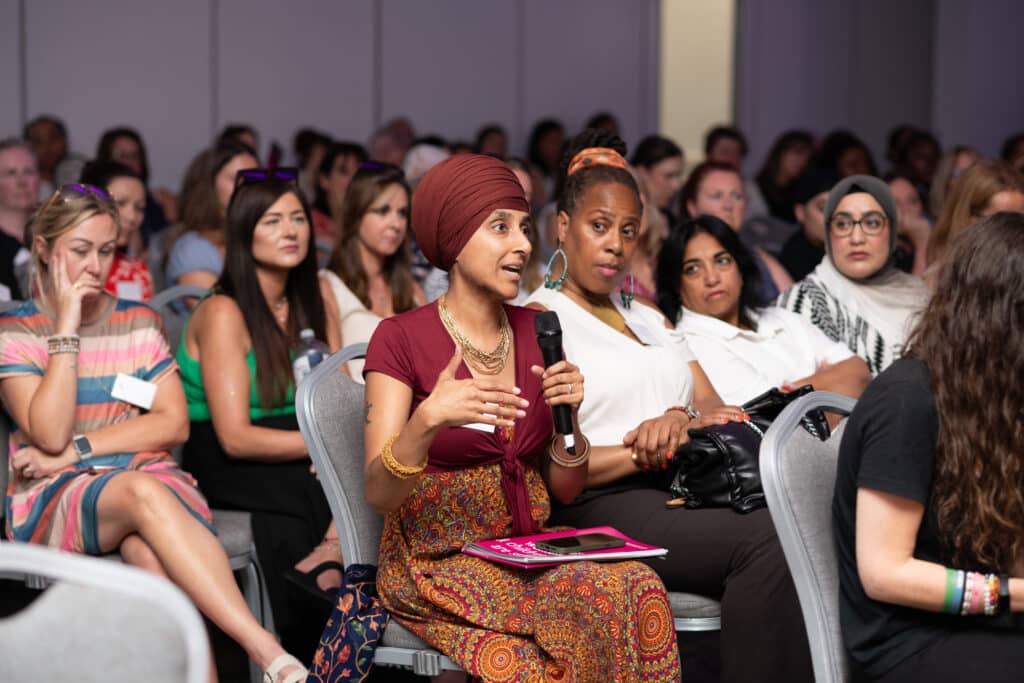 A room full of people with one person holding a microphone