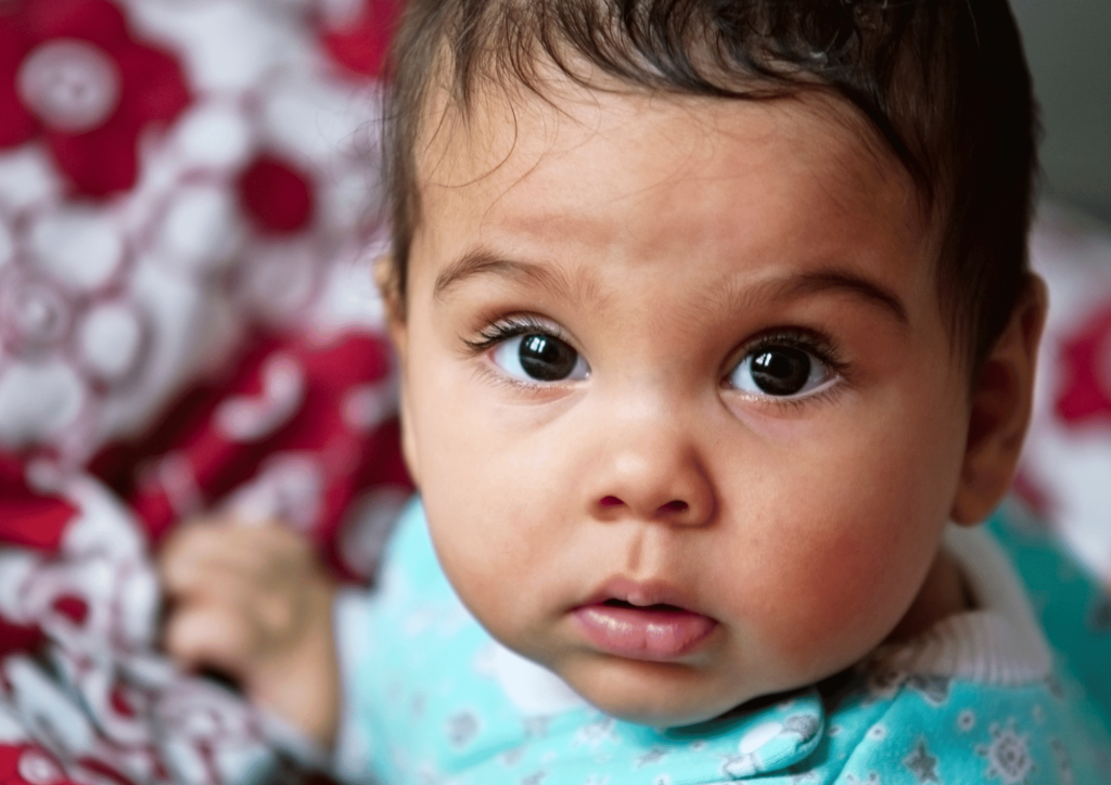 Picture of a young baby looking into the camera.